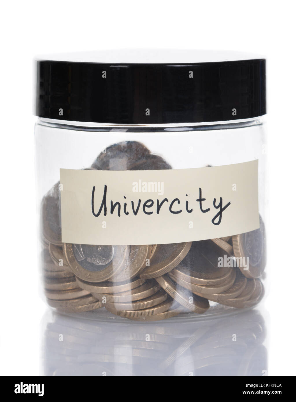 Vaso di vetro dell'università riempito con le monete isolate su sfondo bianco Foto Stock