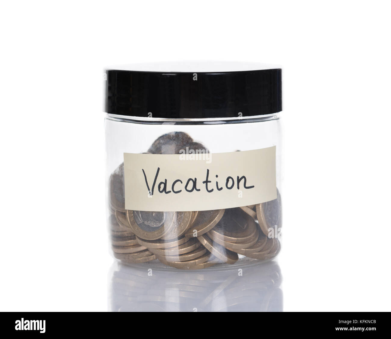 Vaso di vetro per le vacanze riempito con monete isolate su sfondo bianco Foto Stock