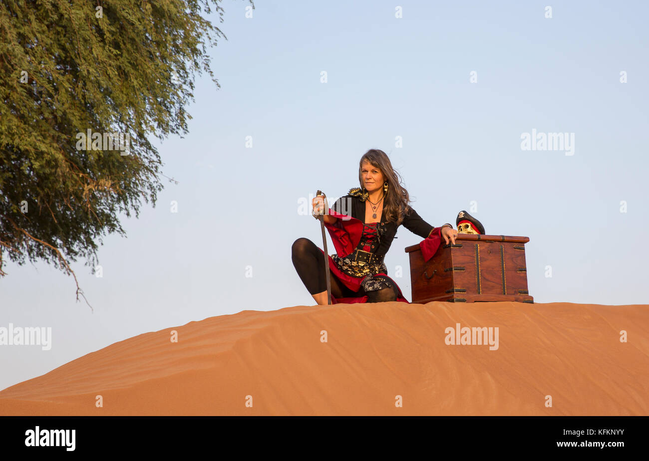 Lady pirata in un deserto con un tesoro Foto Stock