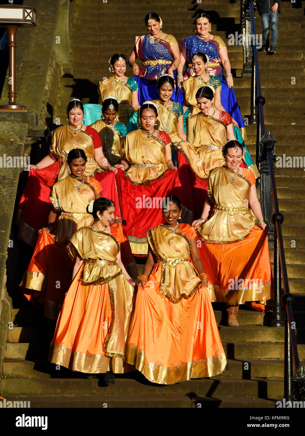 Un gruppo di danzatori indiani a piedi giù i passaggi in Princes Street Gardens per eseguire l'annuale Diwali Festival di Edimburgo. Foto Stock