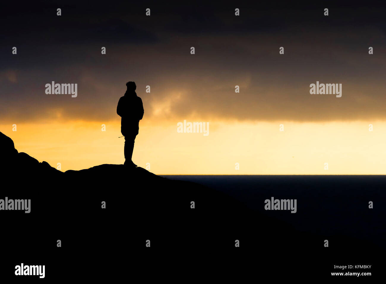 Silhouette - un uomo solitario stagliano contro la luce della sera. Foto Stock