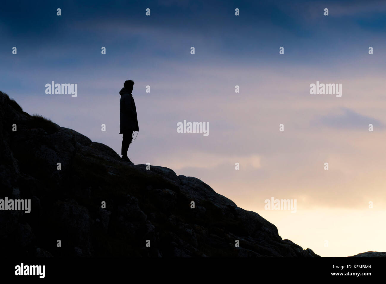 Silhouette - un uomo solitario stagliano contro la luce della sera. Foto Stock