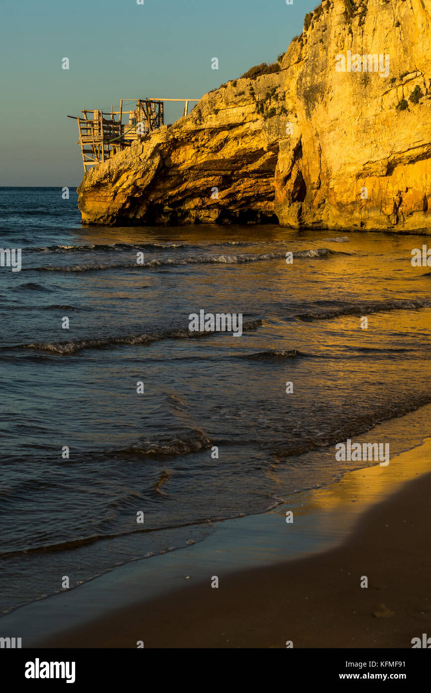 I promontori rocciosi di Peschici, Italia punteggiato di pesca tradizionali torri chiamato trabucco, il Parco Nazionale del Gargano in Puglia. Foto Stock