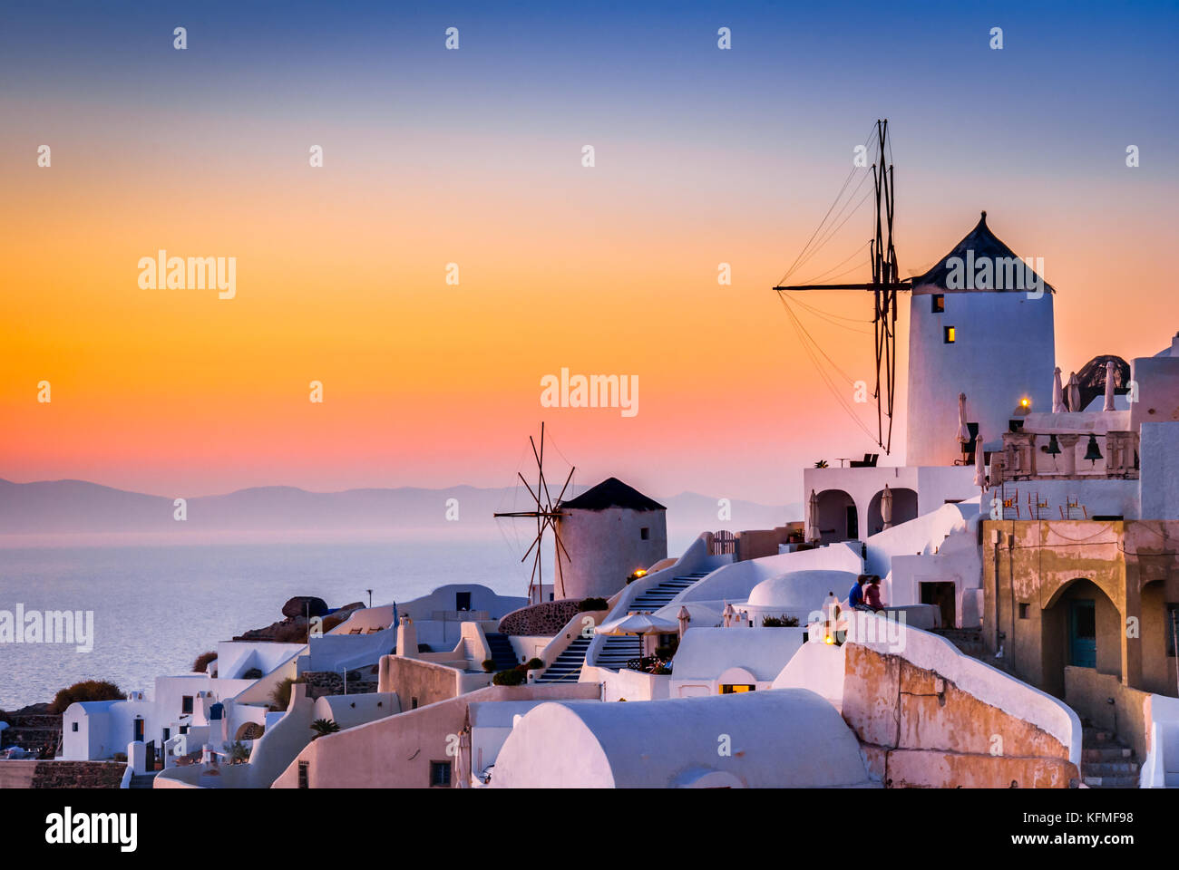 Santorini, Grecia. Famosa attrazione del villaggio di Oia al tramonto con il mulino a vento nelle isole greche del Mar Egeo. Foto Stock