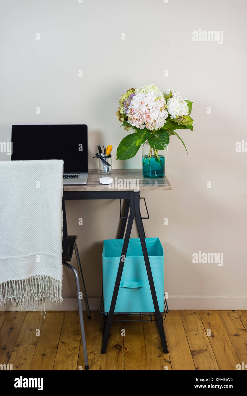 Splendidamente curata scrivania, computer portatile di lavoro e ortensie, Foto Stock