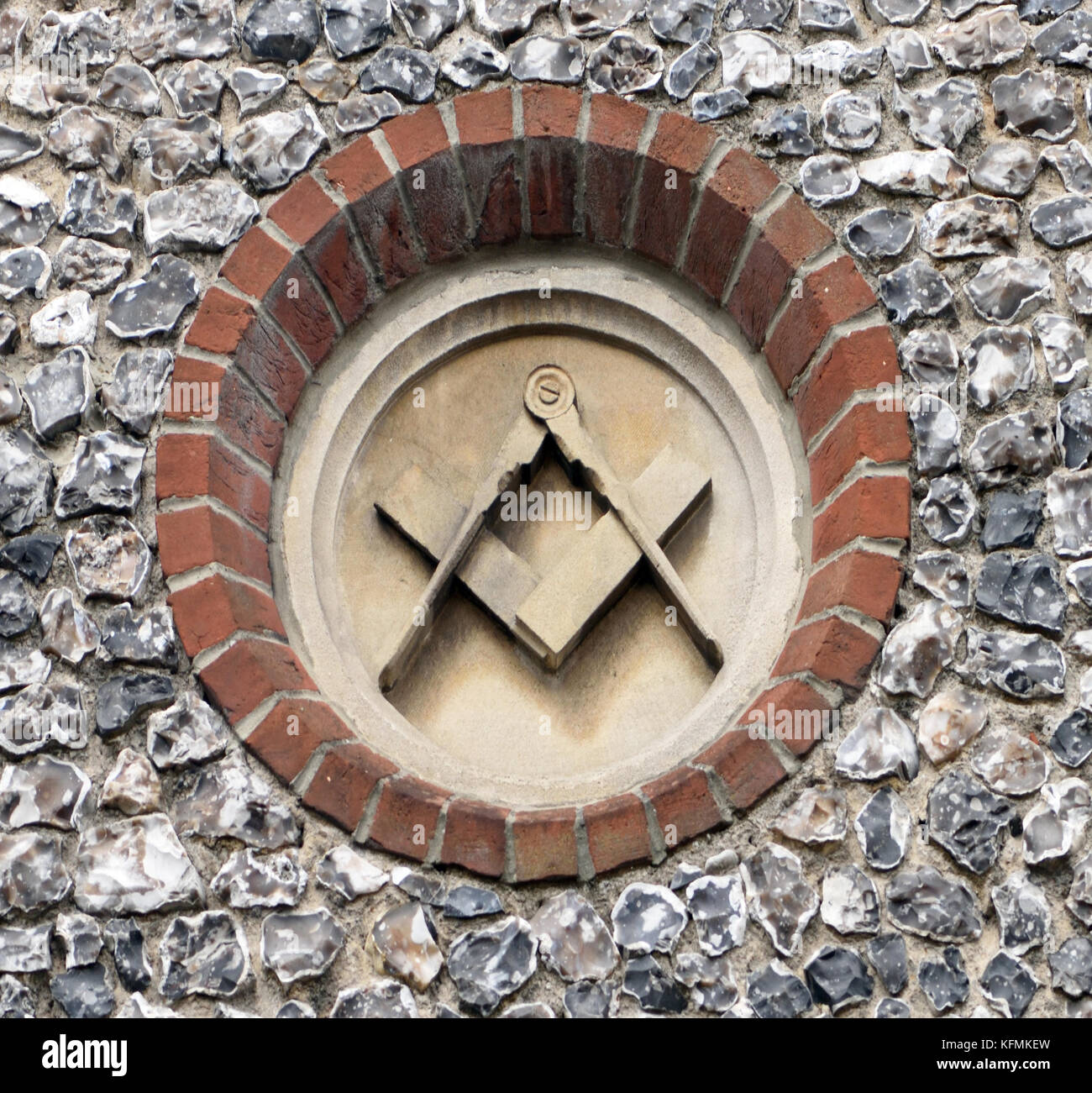 Bussole e un quadrato, masonic simboli scolpiti sulla pietra piaghe in una parete di pietra focaia su un vecchio Masonic hall. Winchester, Hampshire, Regno Unito Foto Stock