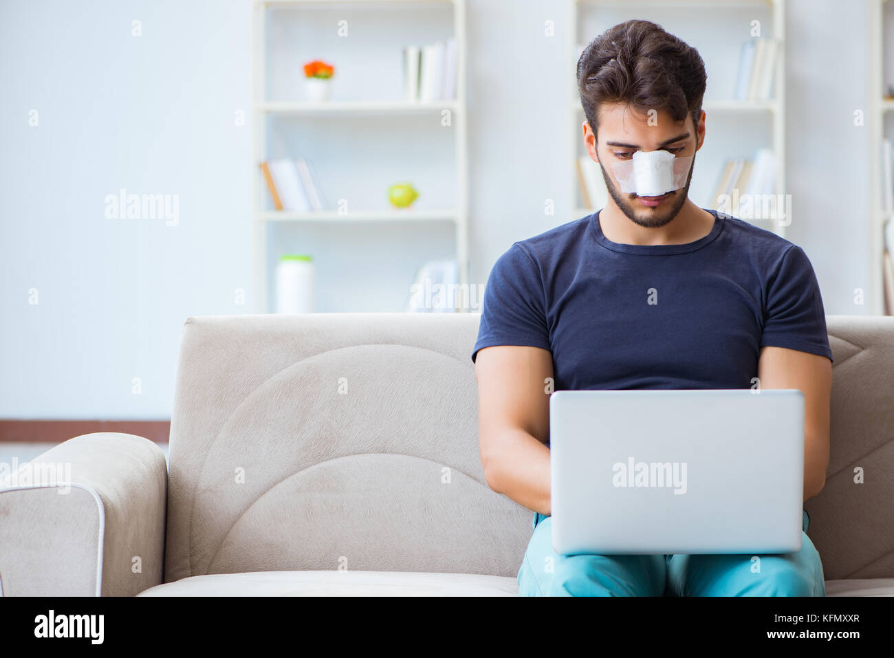 Giovane uomo recuperando la guarigione a casa dopo un intervento di chirurgia plastica naso job Foto Stock