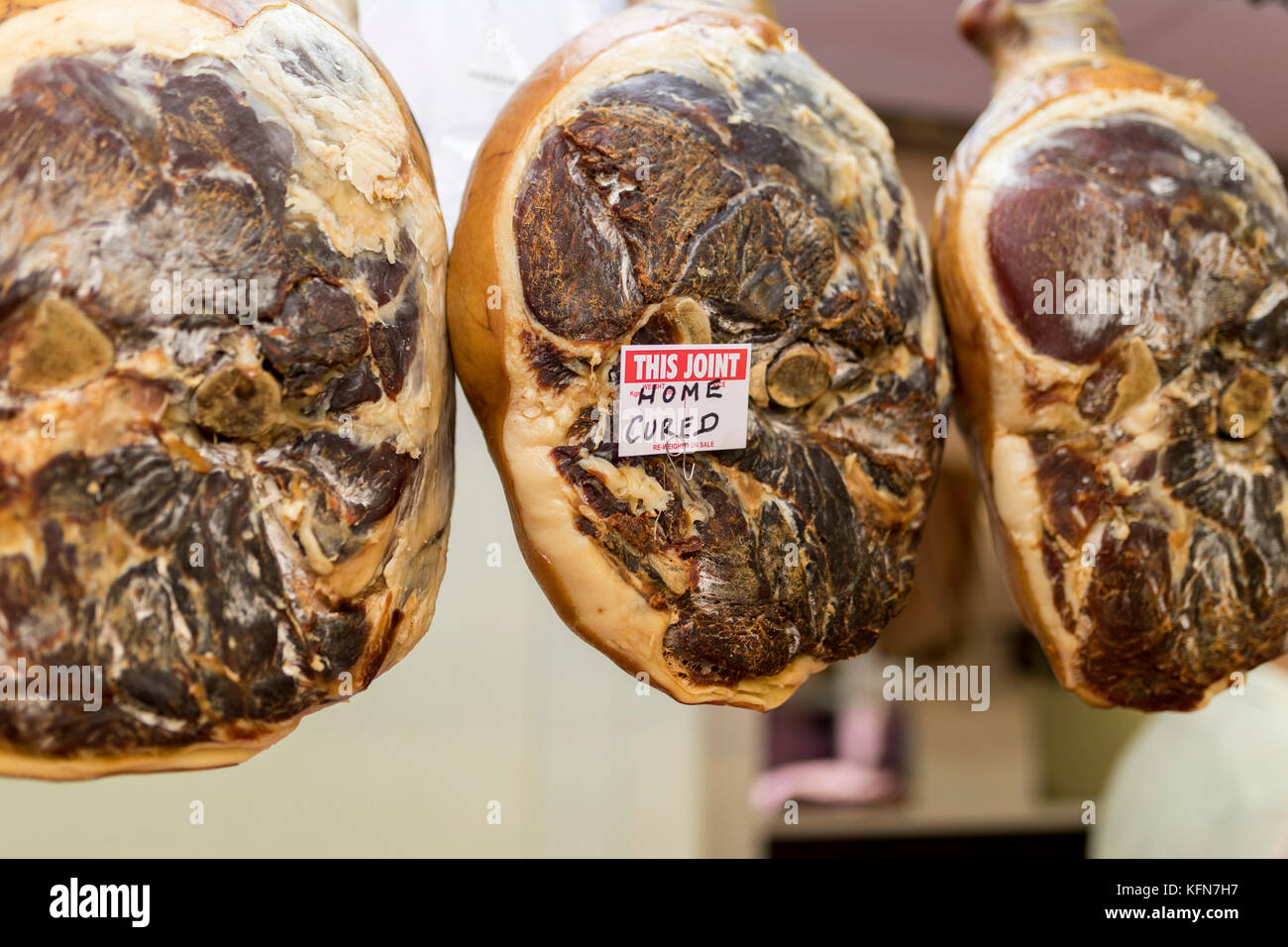 Scelta e home premium indurito giunti di maiale appeso in un negozio di macellaio su un mercato in stallo in Inghilterra, Regno Unito Foto Stock