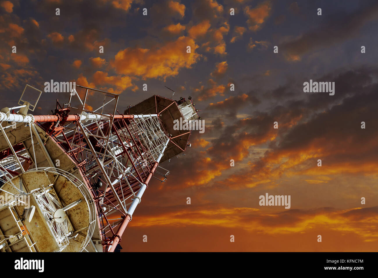 La torre della TV e delle telecomunicazioni piano della torre contro il cielo blu, rosso e bianco Foto Stock