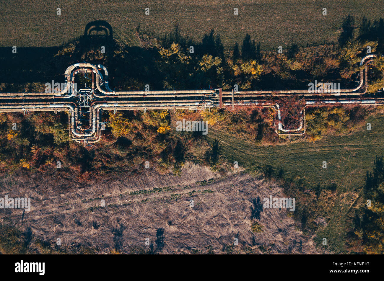 Vista aerea di abbandonato all'aperto riscaldamento industriale pipeline. vista superiore di calore tubi di vapore attraverso il paesaggio rurale da fuco pov. Foto Stock