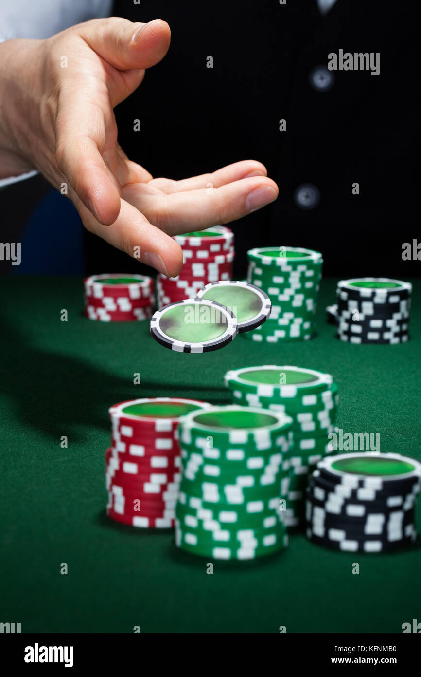 Primo piano di mano con gettando chip da gioco Foto Stock