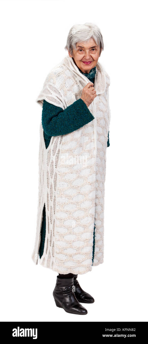 Un grazioso old Lady in vestiti a maglia in piedi contro uno sfondo bianco. Foto Stock