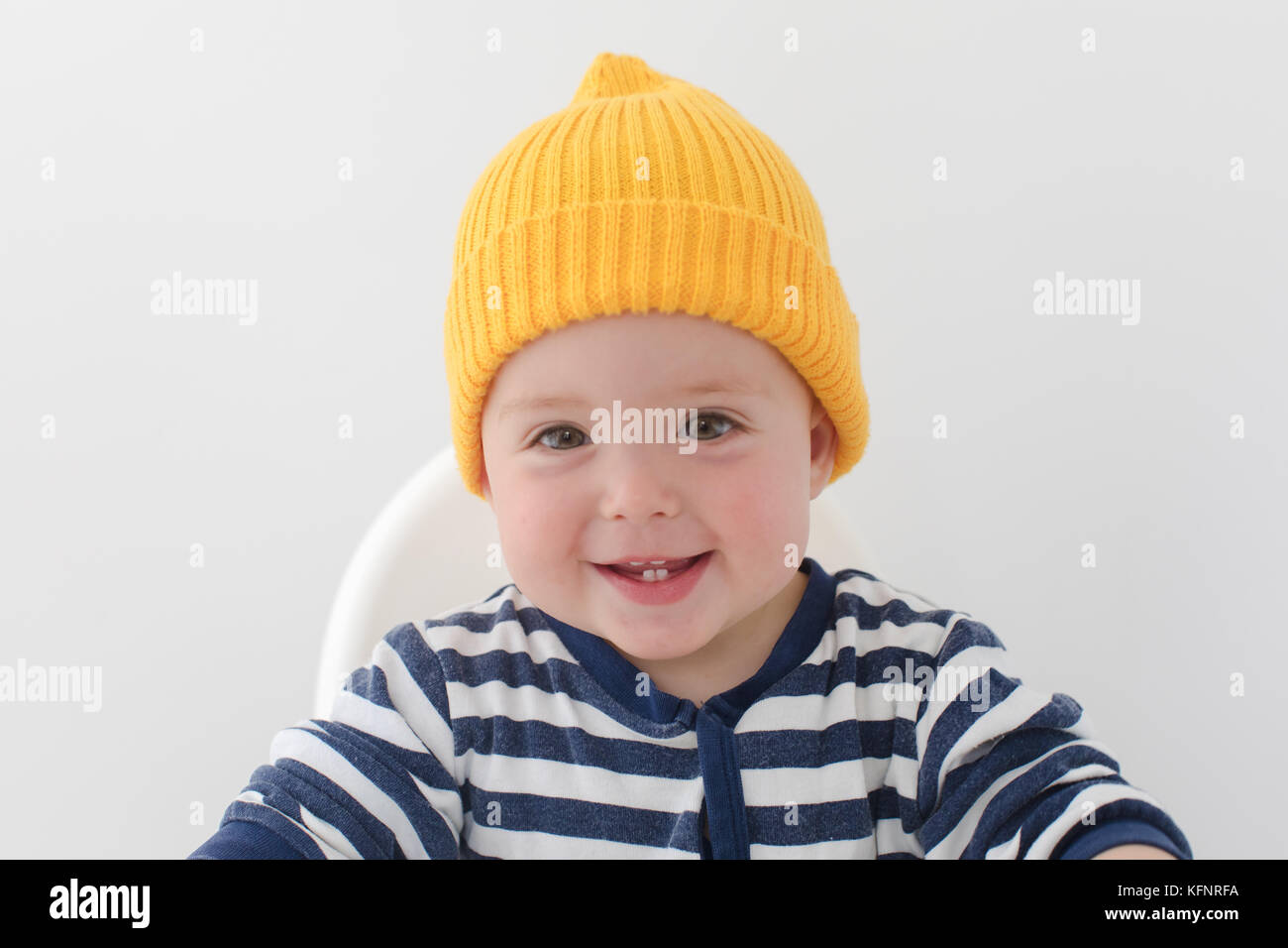 Bambino in un cappello giallo con due primi denti studio Foto Stock