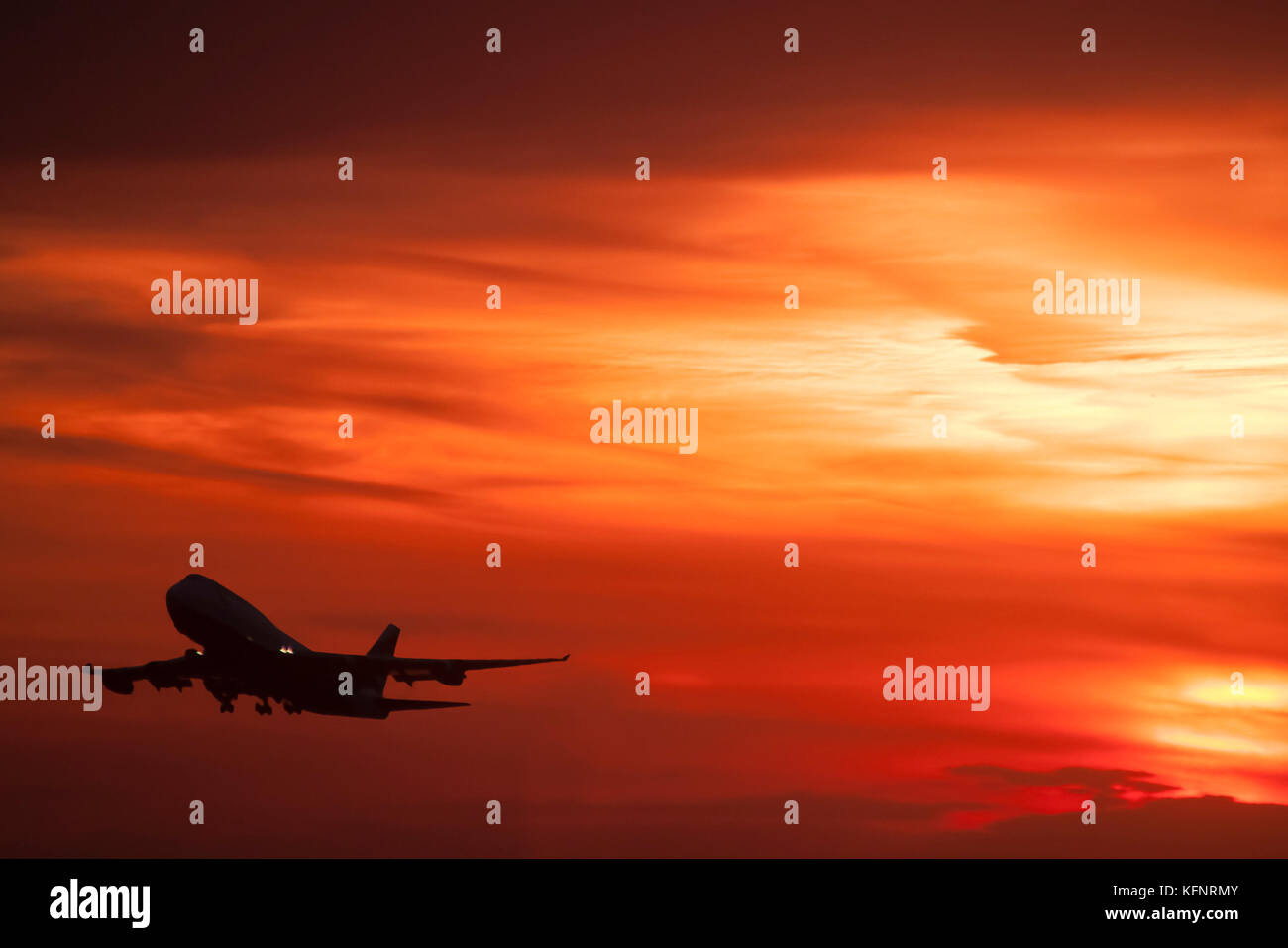747 aereo di linea prendendo il largo per l'altro lato del mondo al tramonto Foto Stock