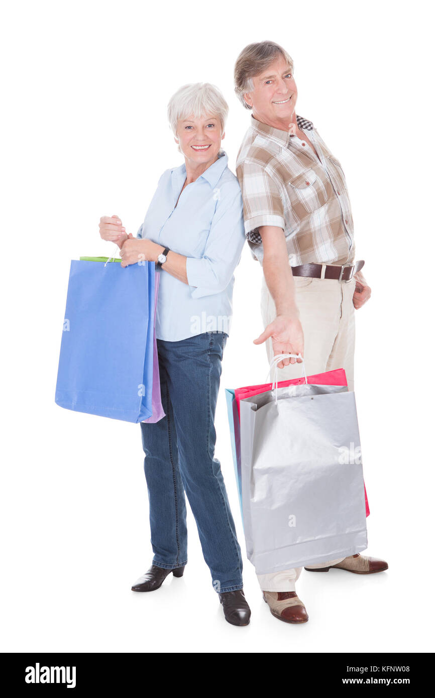 Felice coppia Senior Azienda Shopping Bag su sfondo bianco Foto Stock