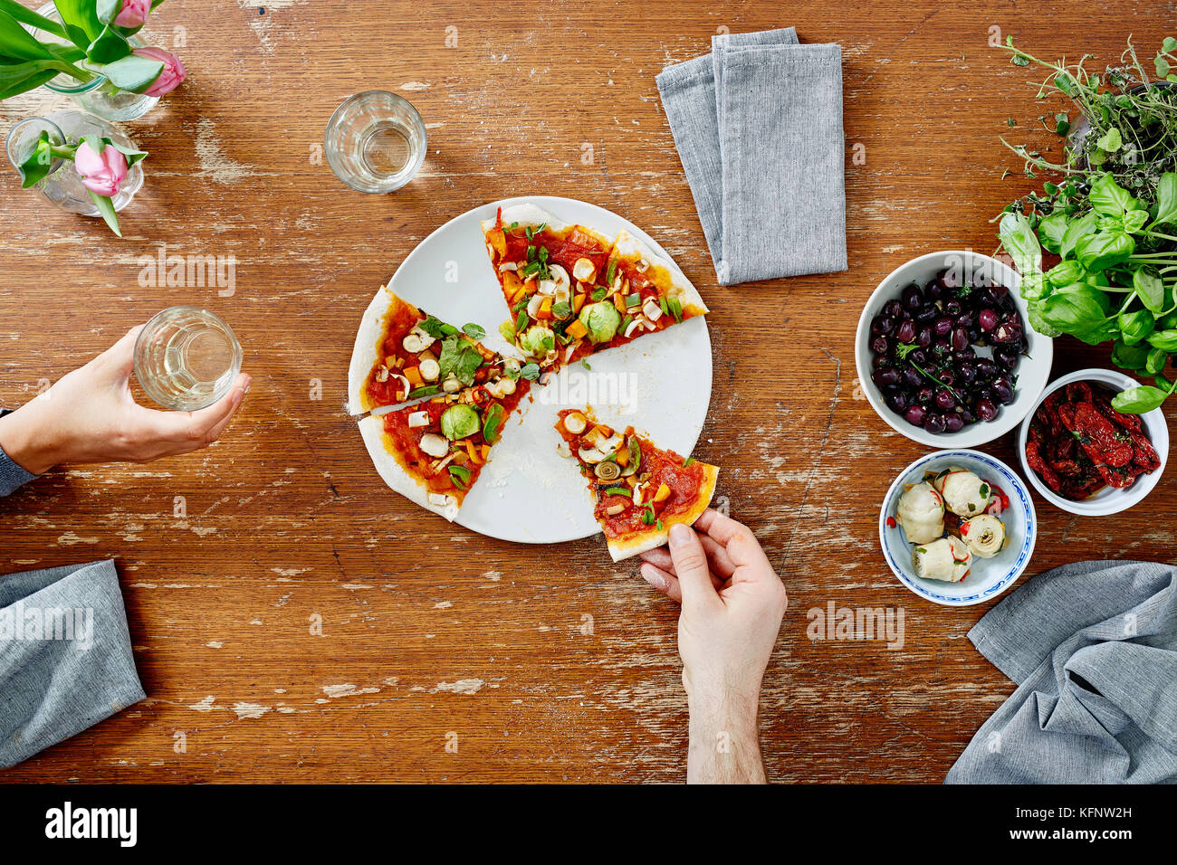 Mangiare e condividere pizza organico a cena Foto Stock