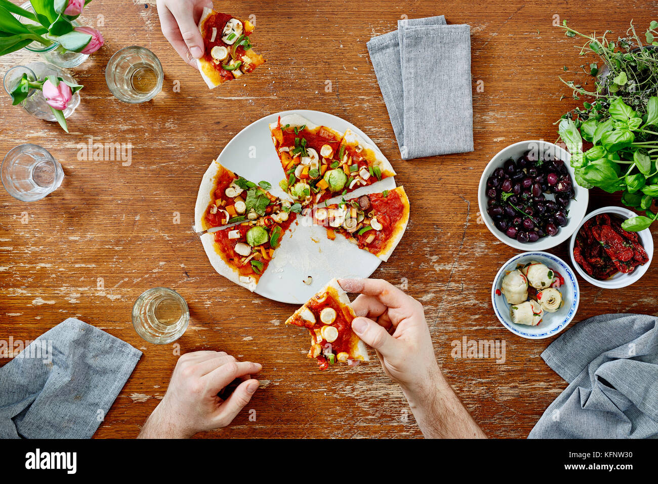 Ottenere sociale insieme a cena due peoplehaving pizza e bere il vino Foto Stock