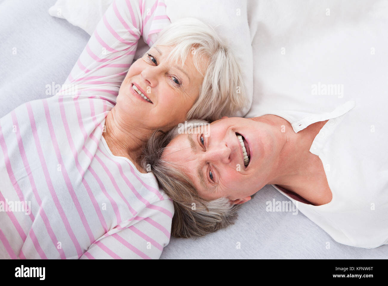 Felice coppia Senior affiancati sul letto Foto Stock