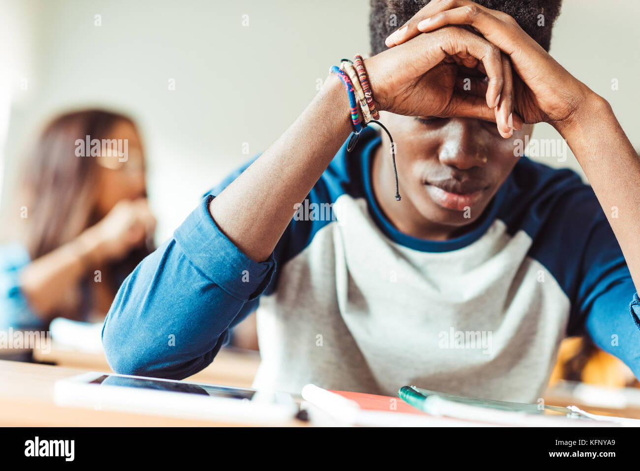 African American studente seduto in classe Foto Stock