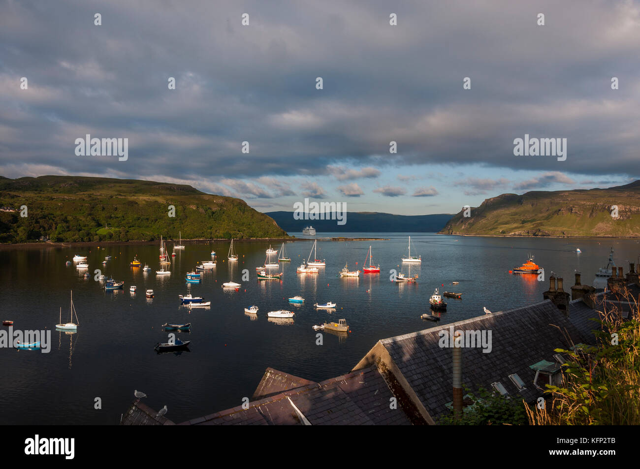 Vista del porto nella città di portree con barche nella baia e una nave da crociera di lasciare il porto, nell'isola di Skye in Scozia, Regno Unito Foto Stock