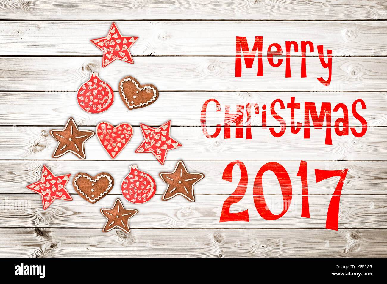 Natale biglietto di auguri 2017, ornamenti in stile rustico su tavole di legno sfondo creando la forma di un albero di natale Foto Stock