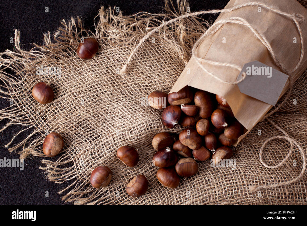 Castagne commestibili - di un sacco di fresco, materie castagne spruzzata sul tavolo Foto Stock