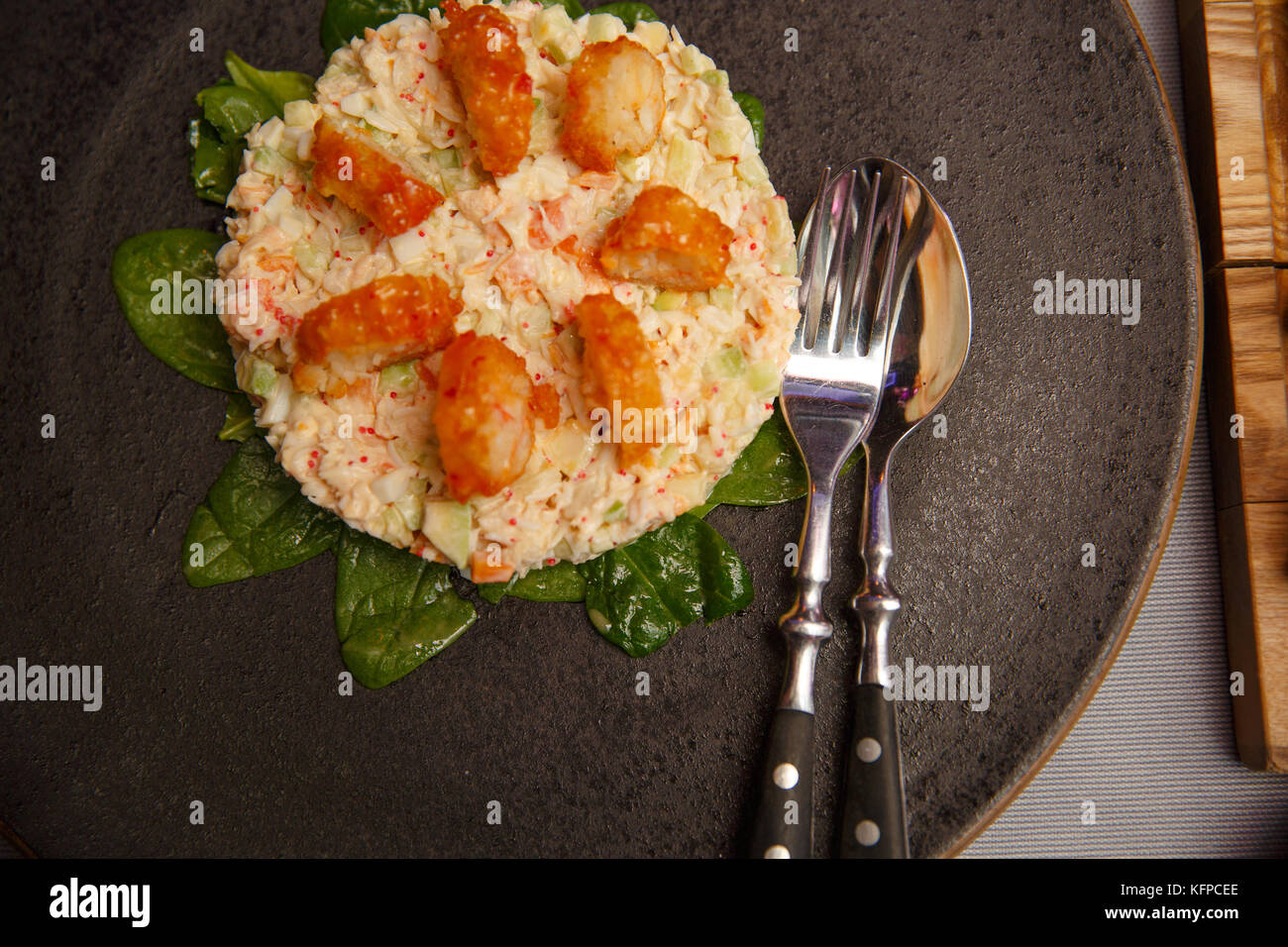 Insalata condita con maionese, bastoncini di granchio, cetriolo, di pepe e di uovo sulla piastra. ristorante feed. Anno nuovo, Natale Foto Stock