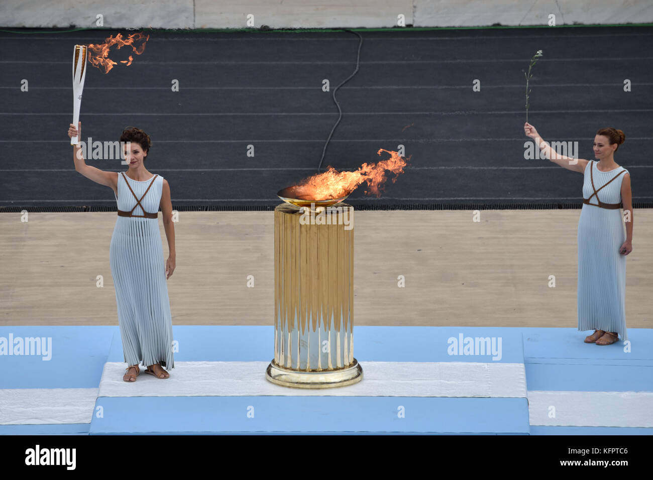 Atene, Grecia, 31 ottobre, 2017. sacerdotessa katerina lehou trattiene il olympictorch nella parte anteriore della caldaia durante la cerimonia di consegna della fiamma olimpica per la pyeongchang 2018 Olimpiadi invernali a Stadio Panateneico in Atene in Grecia. Credito: nicolas koutsokostas/alamy live news. Foto Stock