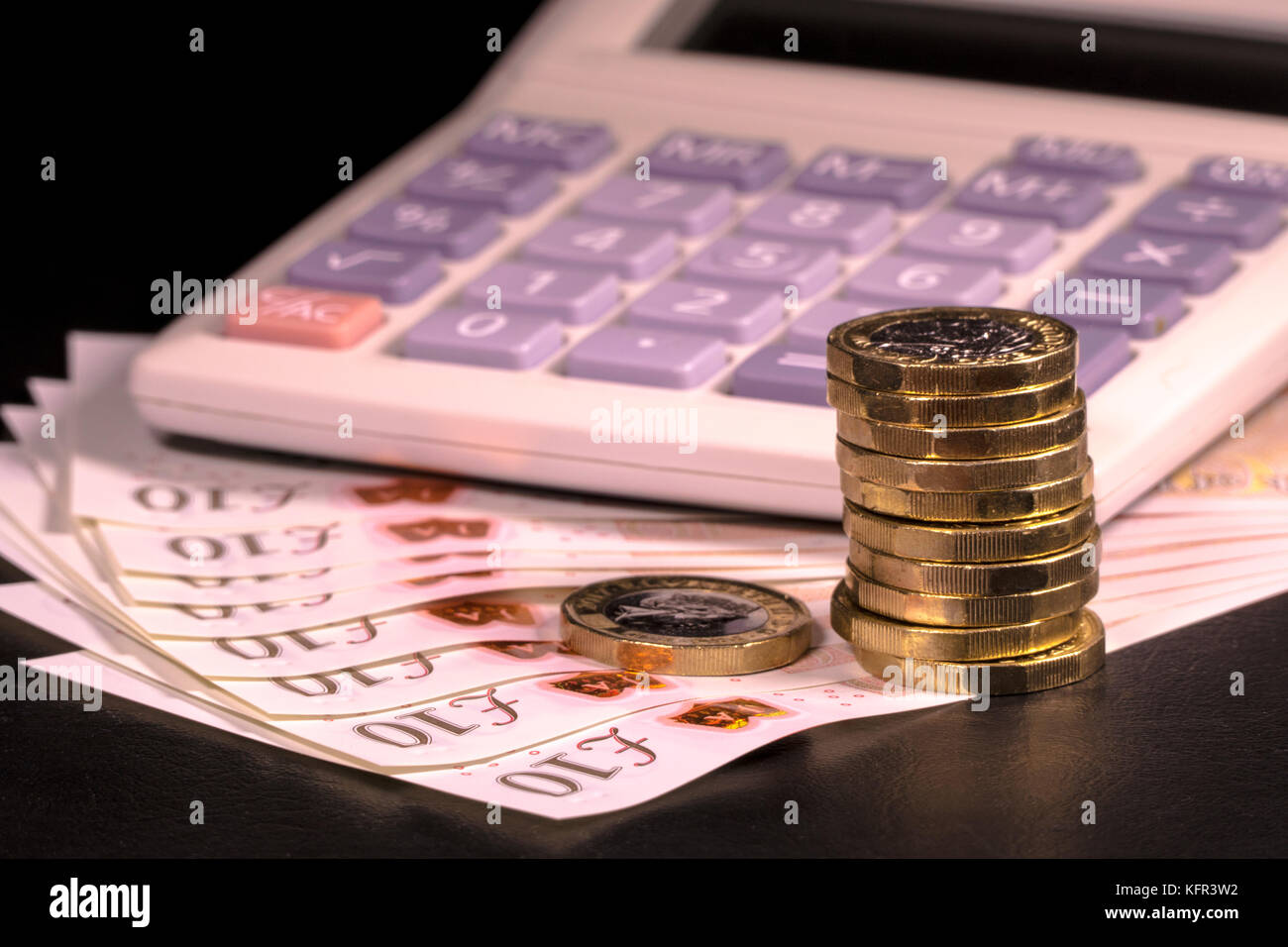 Calcolatrice sul nuovo polimero sterling £10 dieci pound note e nuovo cancelletto di monete. Concetto di calcolo monetario britannico / Regno Unito Sterline moneta. Foto Stock