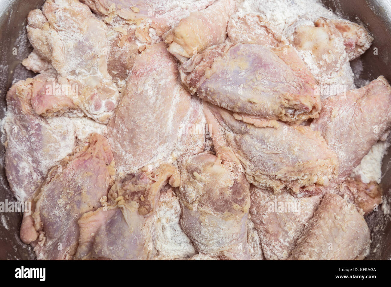 Il pollo crudo ala e coscia rivestita in farina, sale e pepe prima della frittura. cibo sfondo. Foto Stock