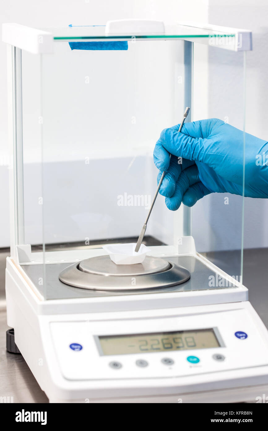 Scienziato utilizzando una bilancia analitica in laboratorio Foto Stock