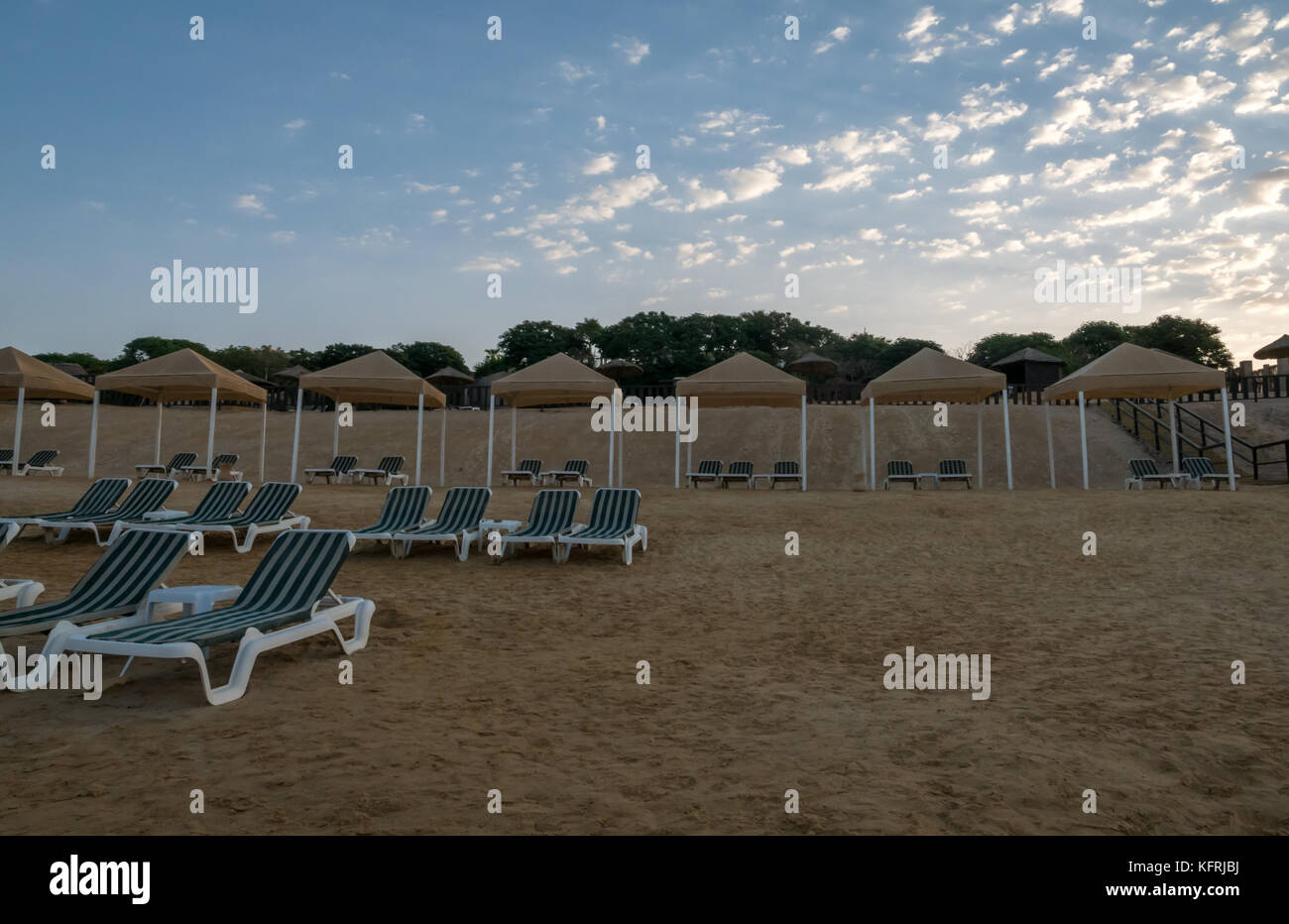 Presto la luce del mattino al Holiday Inn Dead Sea Resort con spiaggia vuota di sedie a sdraio, Giordania, Medio Oriente Foto Stock