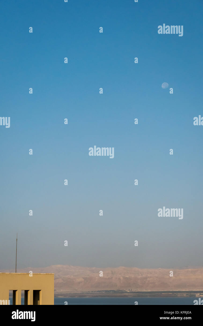 La mattina presto luce di sunrise al Holiday Inn Dead Sea beach resort, Giordania, Medio Oriente con la luna nel cielo e vista della Cisgiordania Foto Stock
