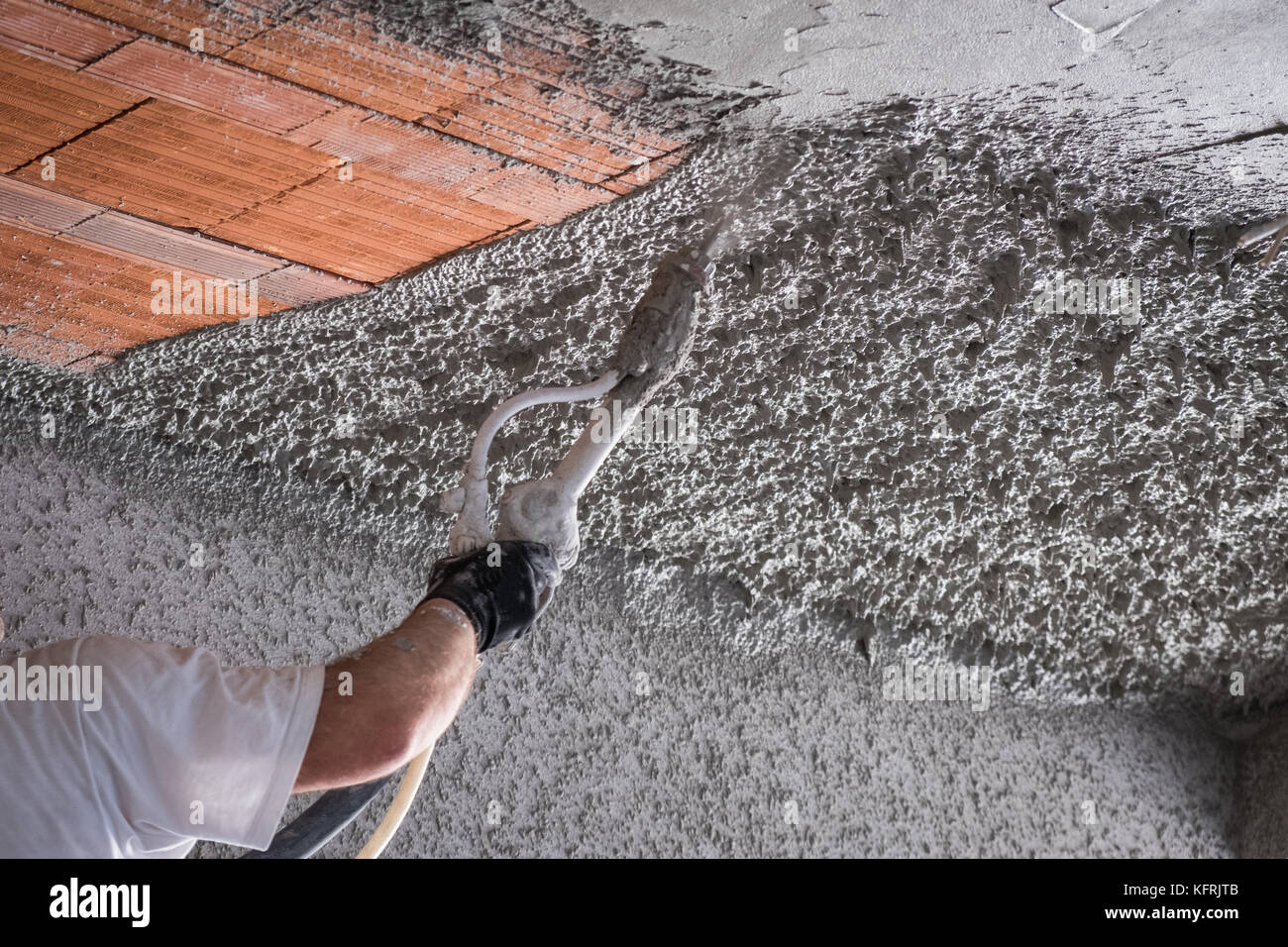 Operaio edile di applicare il cemento intonaco sul soffitto con macchina  intonacatrice Foto stock - Alamy
