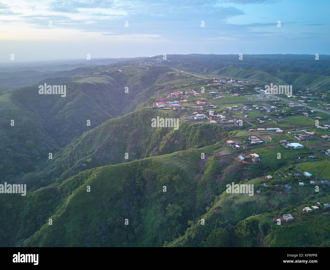 Vista aerea su piccole città nella natura sulle verdi colline sfondo. piccolo e povero paese Foto Stock