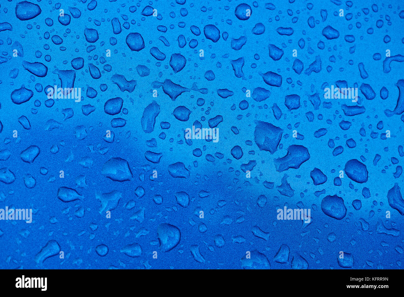 Gocce d'acqua blu su sfondo di metallo. gocce di pioggia sulla texture blu close-up Foto Stock