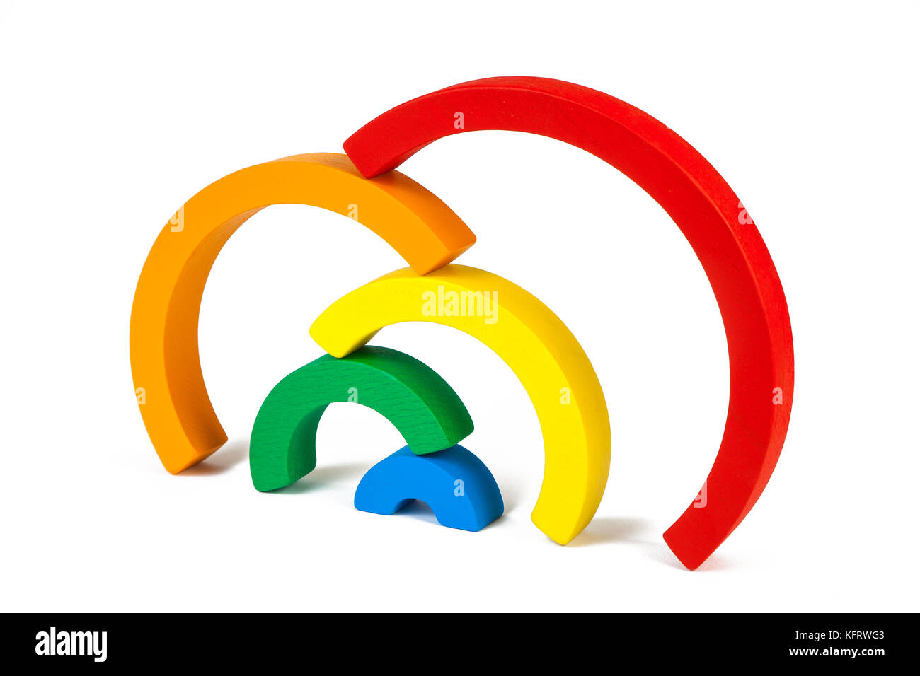 Un giocattolo di legno di sette colori diversi archi nella forma di un arcobaleno su un isolato bianco sfondo, gli archi sono impilati uno sull'altro Foto Stock