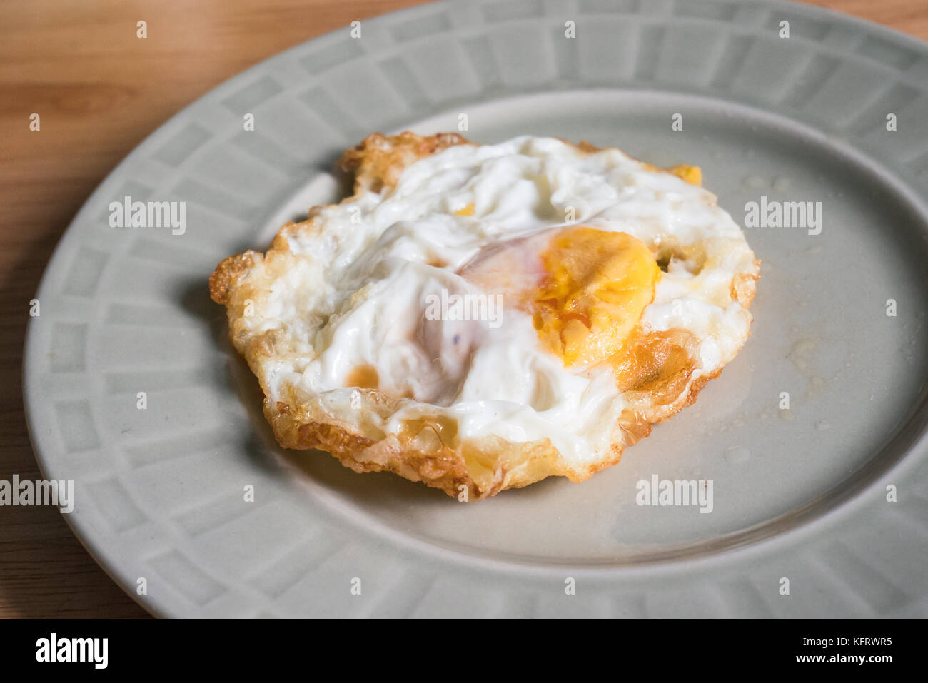 Sunny-Side fino uovo fritto in un piatto di portata Foto Stock