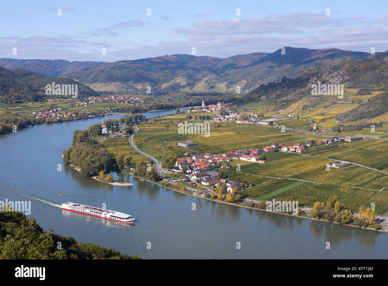La nave da crociera passa per Dürnstein sul Danubio a Wachau, patrimonio dell'umanità dell'UNESCO, con vigneti di colore giallo e arancione autunnale, bassa Austria Foto Stock