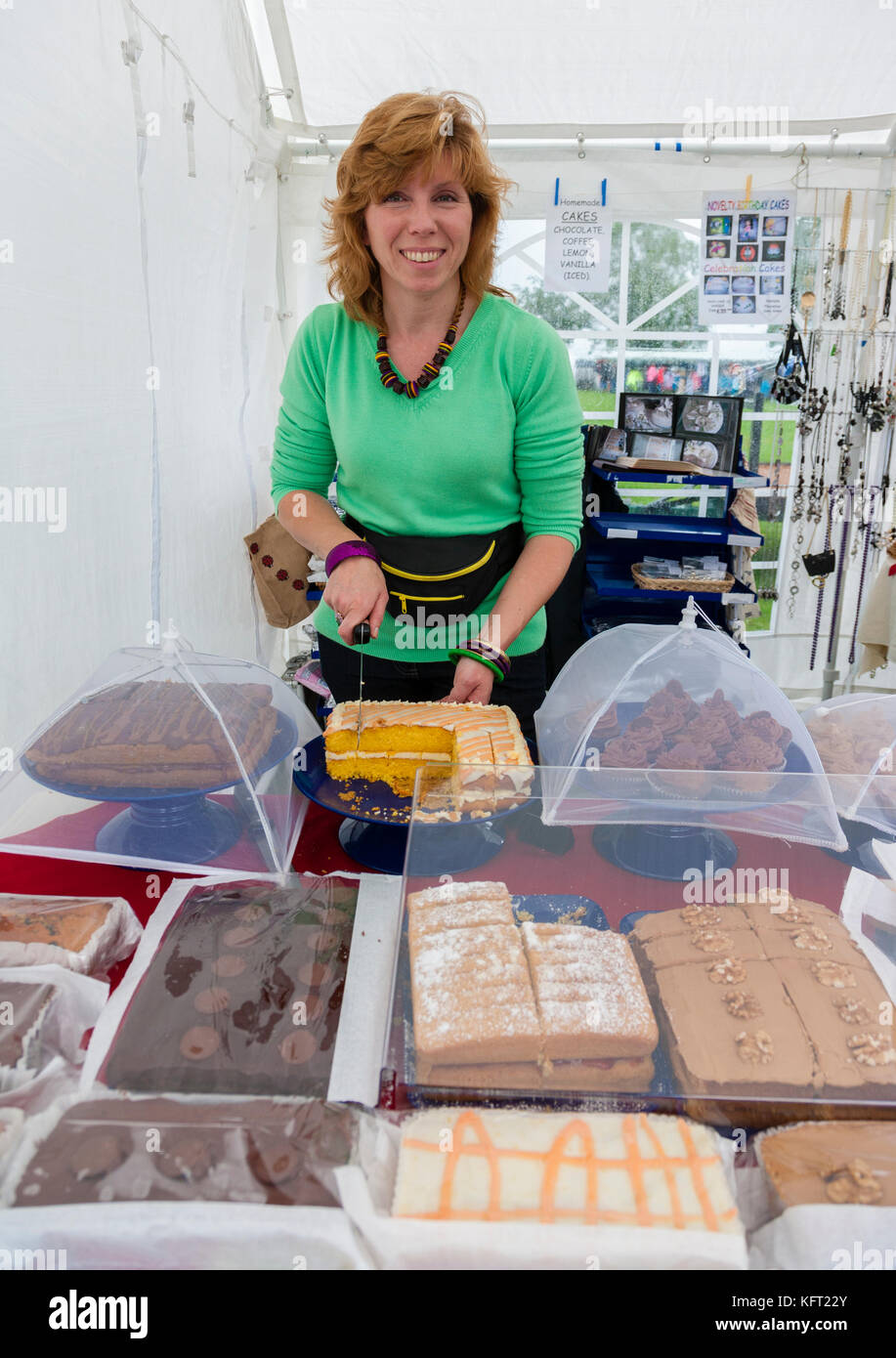 Donna con torte fatte in casa su una bancarella Foto Stock