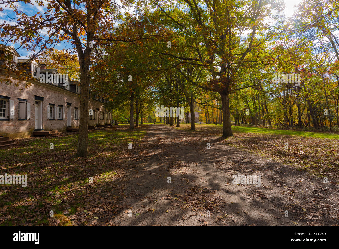 Una passerella dopo una fila di edifici in mattoni di allaire State Park, NJ, Stati Uniti d'America. Foto Stock
