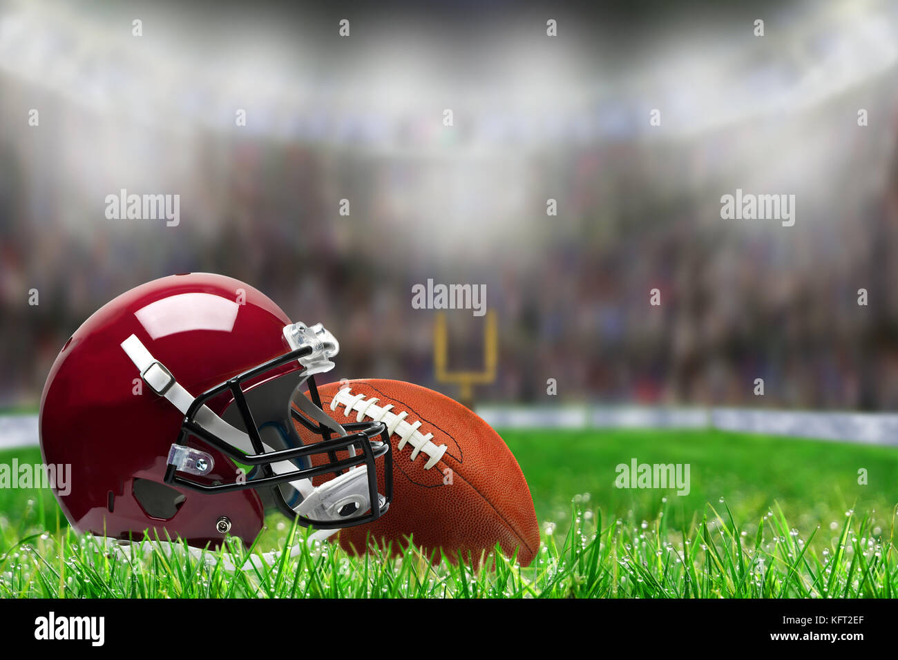 Basso angolo vista di casco da football americano e la palla sul campo in erba deliberata e profondità di campo sulla luminosa sullo sfondo dello stadio con copia spazio. Foto Stock