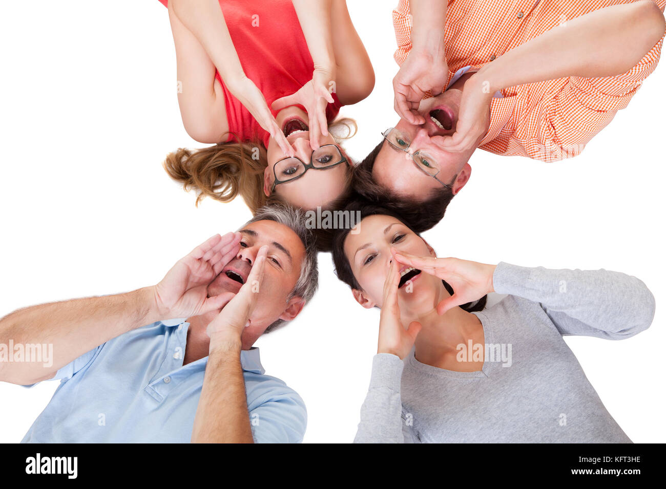 Immagine concettuale di quattro persone di mezza età amici chiamando fuori con le loro mani per le loro bocche e le loro teste insieme isolato su bianco Foto Stock