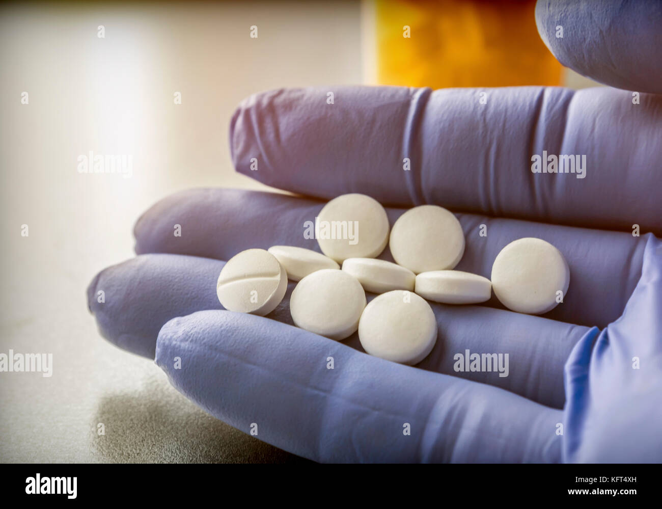 Medico sostiene nella sua mano alcune pillole di bianco Foto Stock