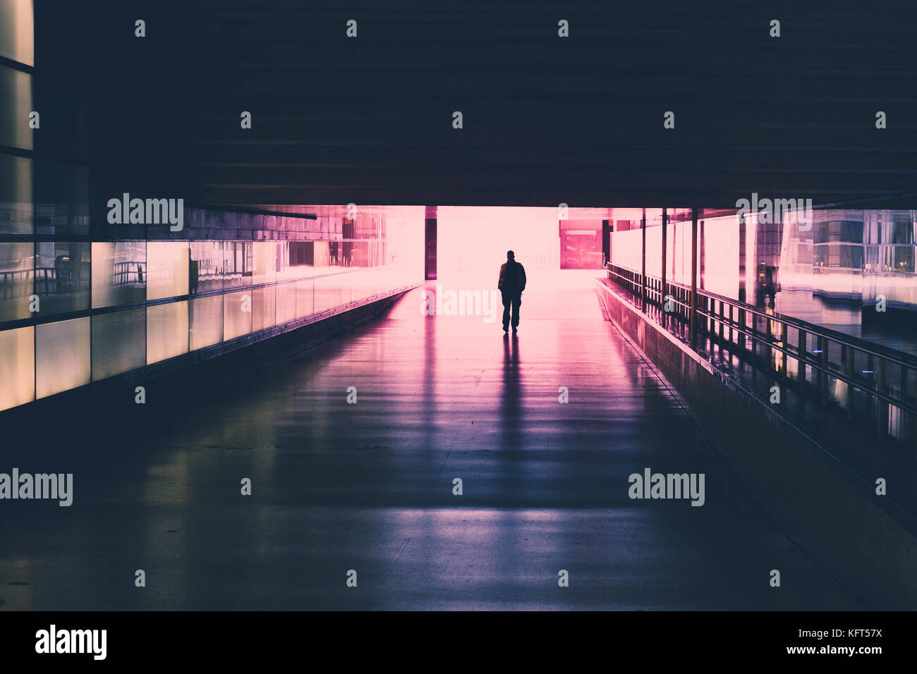 Silhouette di una singola persona che cammina nel tunnel Foto Stock