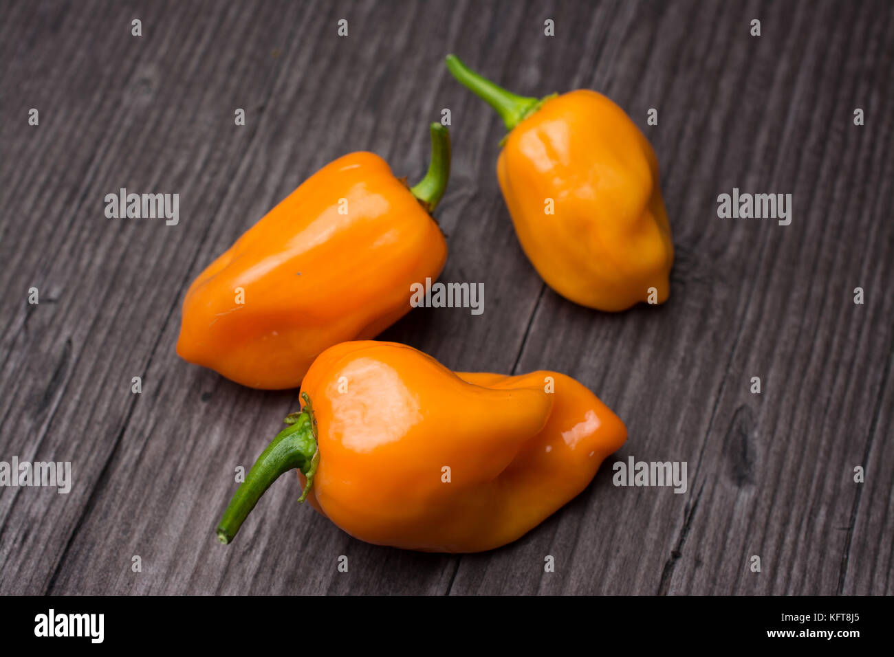 Taluni vegetali di orange peperoncino habanero su legno sfondo vintage Foto Stock