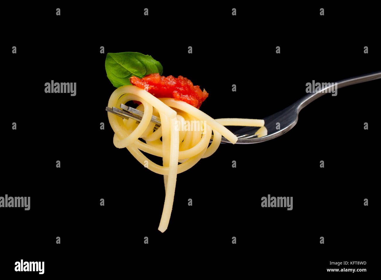 La pasta in sfondo nero. spaghetti, pomodoro e basilico sulla forcella. cucina italiana concept Foto Stock