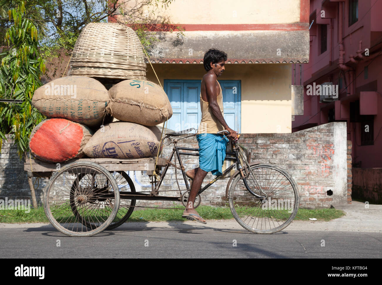 Riso consegnato in triciclo rickshaw carrello nel Bengala occidentale città di Cooch Behar, India Foto Stock