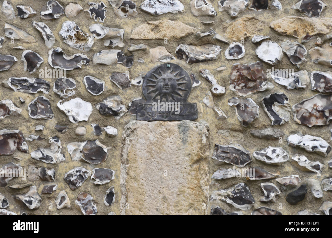 Un incendio di piombo mark per Sun Fire Office con una politica numero stampigliato su di esso inchiodati ad un muro di pietra focaia. Winchester, Hampshire, Regno Unito. Foto Stock