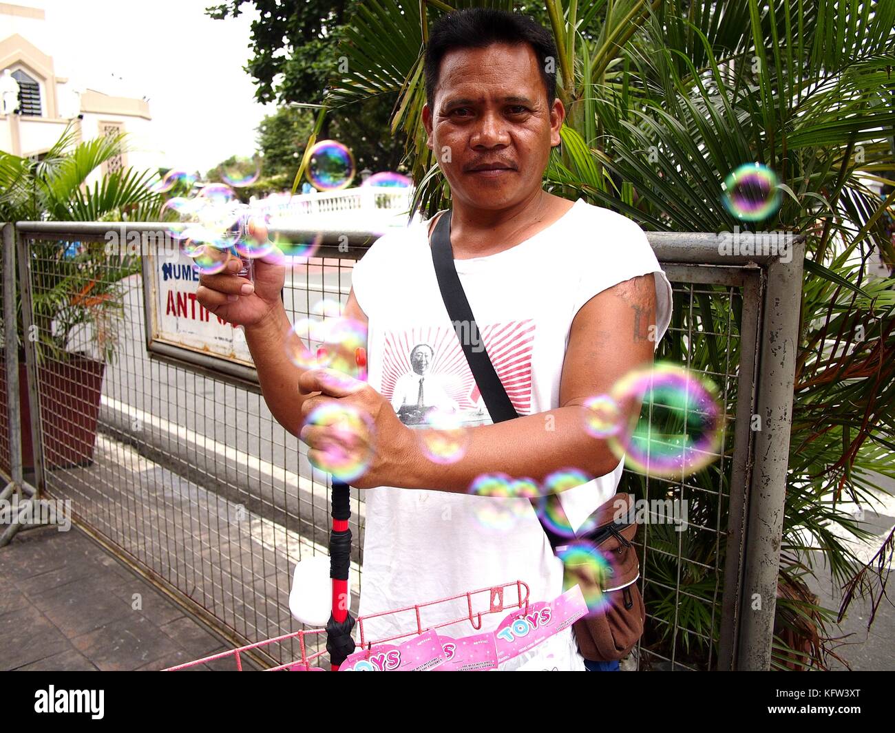 ANTIPOLO CITY, FILIPPINE - 25 OTTOBRE 2017: Un venditore ambulante vende un produttore di bolle ai pedoni. Foto Stock